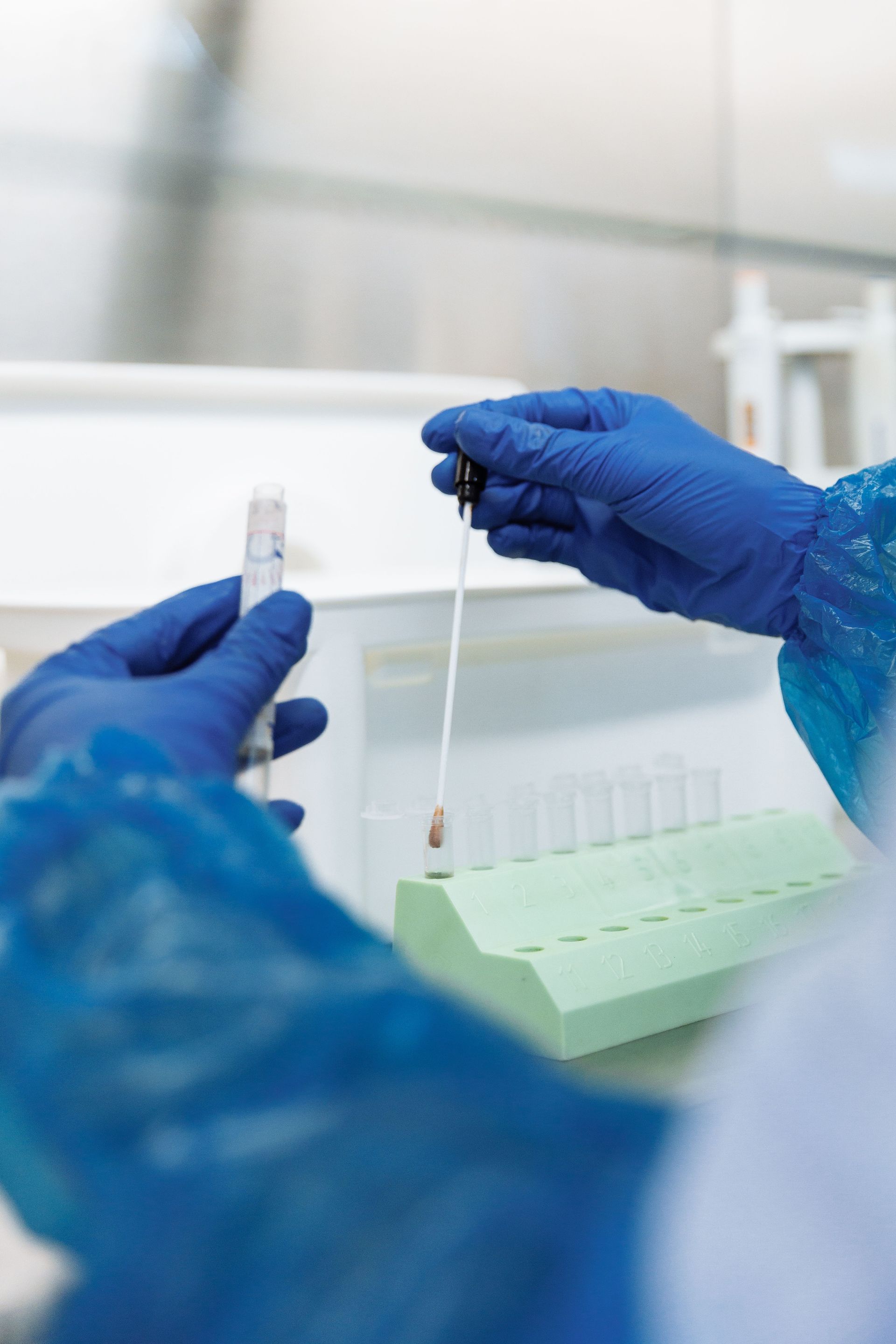 Close-up of a lab technician handling samples in a laboratory setting.